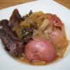 Pot roast with potatoes and onions in white square bowl