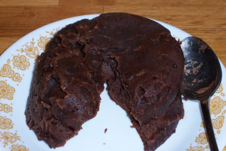 Fast and easy chocolate cake on round plate with brown flowers and spoon