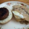 Biscuits and gravy with fried egg on round plate