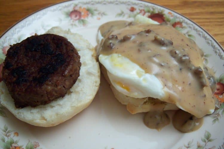 Biscuits and gravy with fried egg on round plate