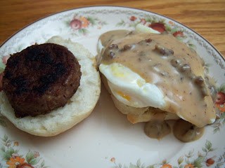 Biscuits and gravy on round plate with fried egg