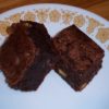 Double Chocolate Chunk Brownies pieces on round white plate with brown flowers