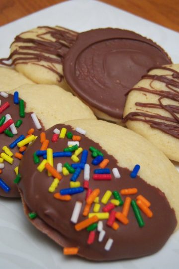 Grandma's All-Occasion Sugar Cookies dipped in chocolate with sprinkles on square white plate