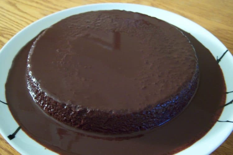 Chocolate Amaretti Torte covered in ganache on large round white plate