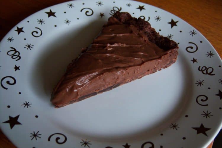 Chocolate Cream Tart slice on round white plate with gold stars and swirls