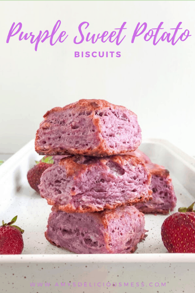 Stack of purple sweet potato biscuits on white sheet tray with whole strawberries