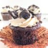 Oreo Cupcakes with Cream Cheese Buttercream with liner peeled back, extra cupcakes in the background