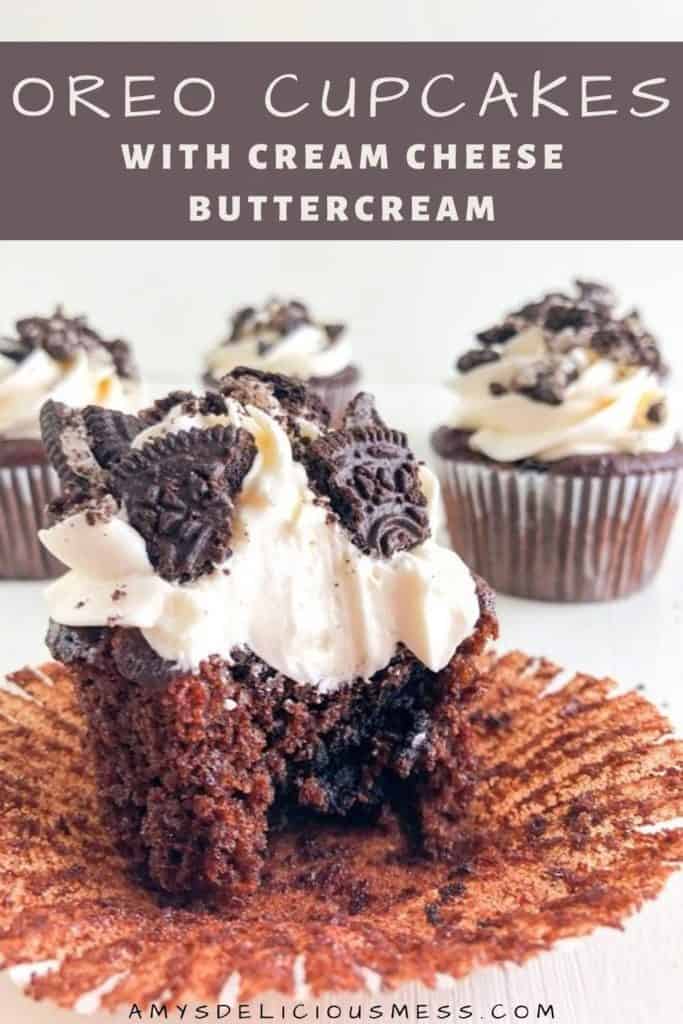Oreo Cupcakes with Cream Cheese Buttercream with liner peeled back and bite taken, extra cupcakes in the background